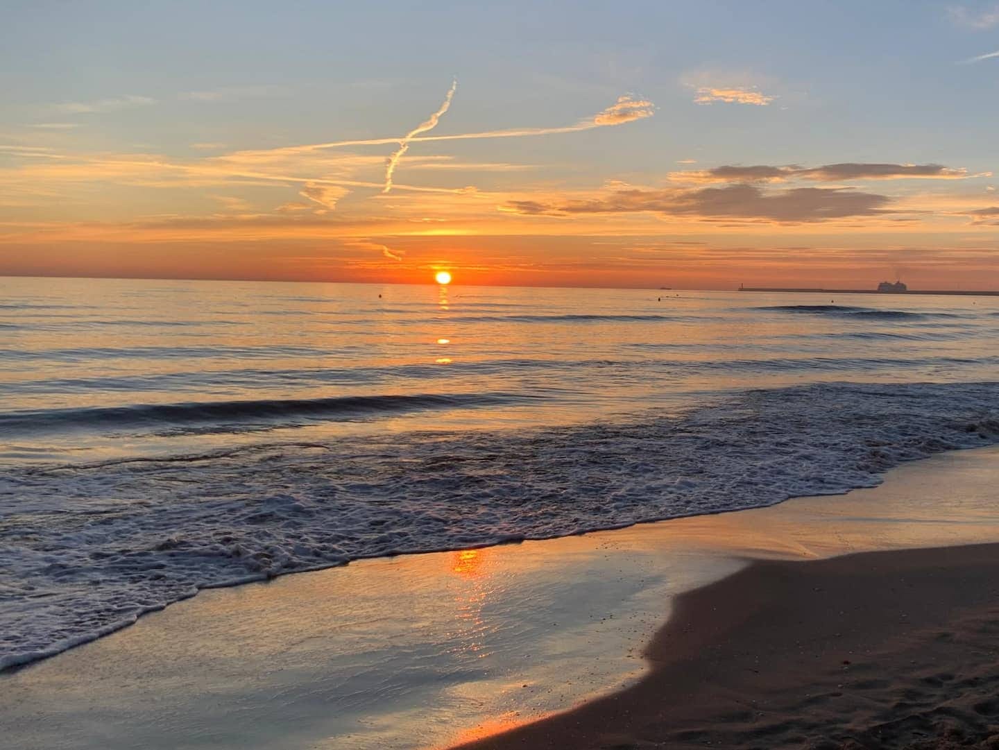 Amanecer sobre el mar y la orilla de la playa de la Malvarrosa